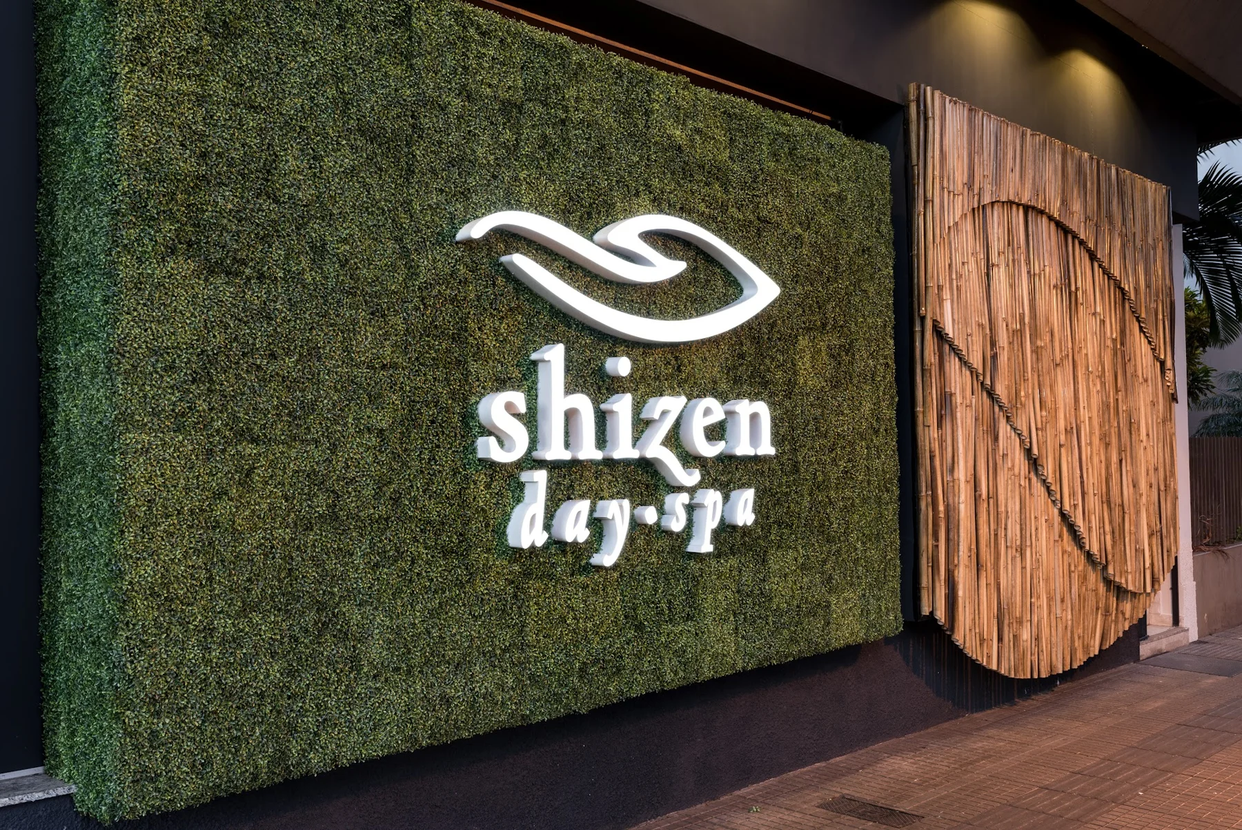 Entrada Shizen Day Spa com a marca na parede verde